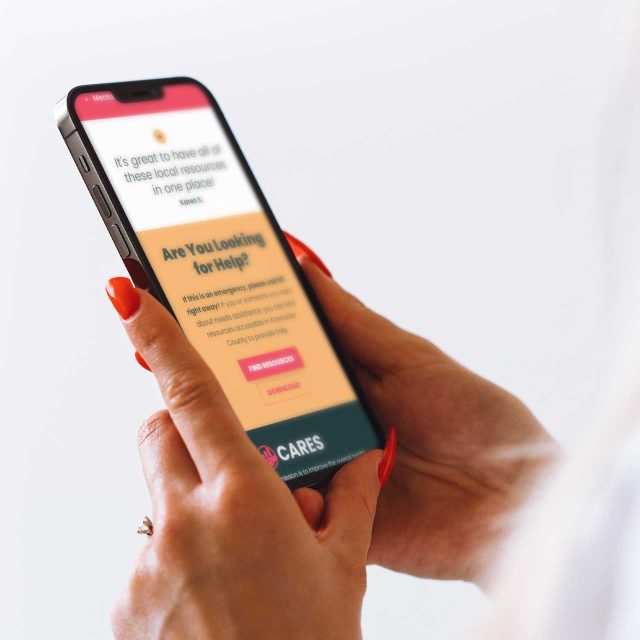 Person holding smartphone with text about local resources and help options.