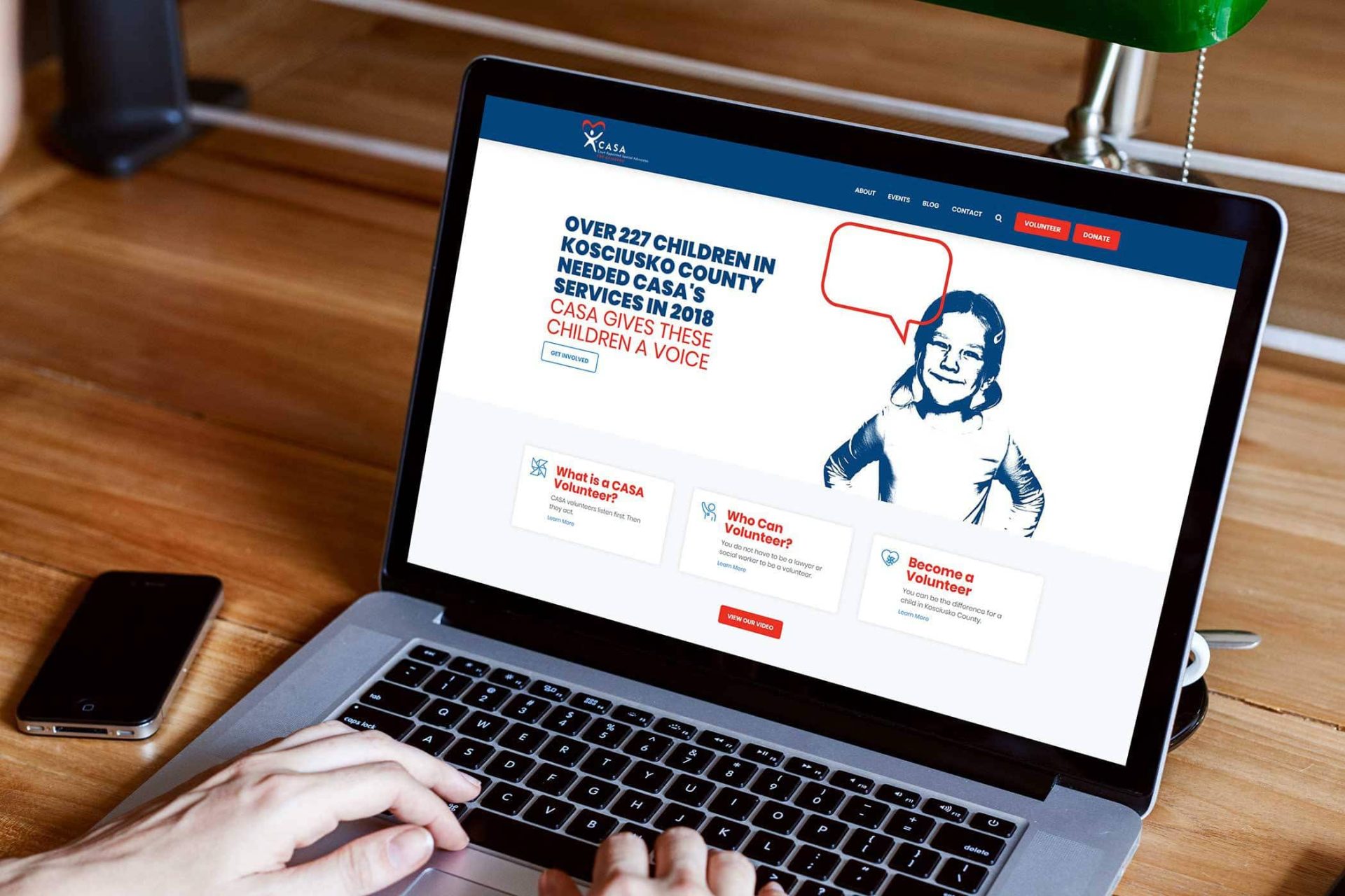 Person using a laptop showing a CASA volunteer webpage.