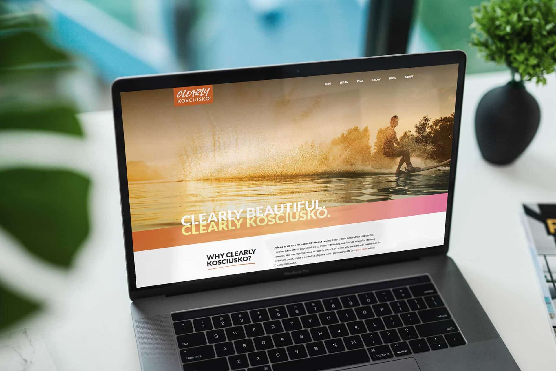 Laptop showcasing EVI Training website with a waterskiing image.