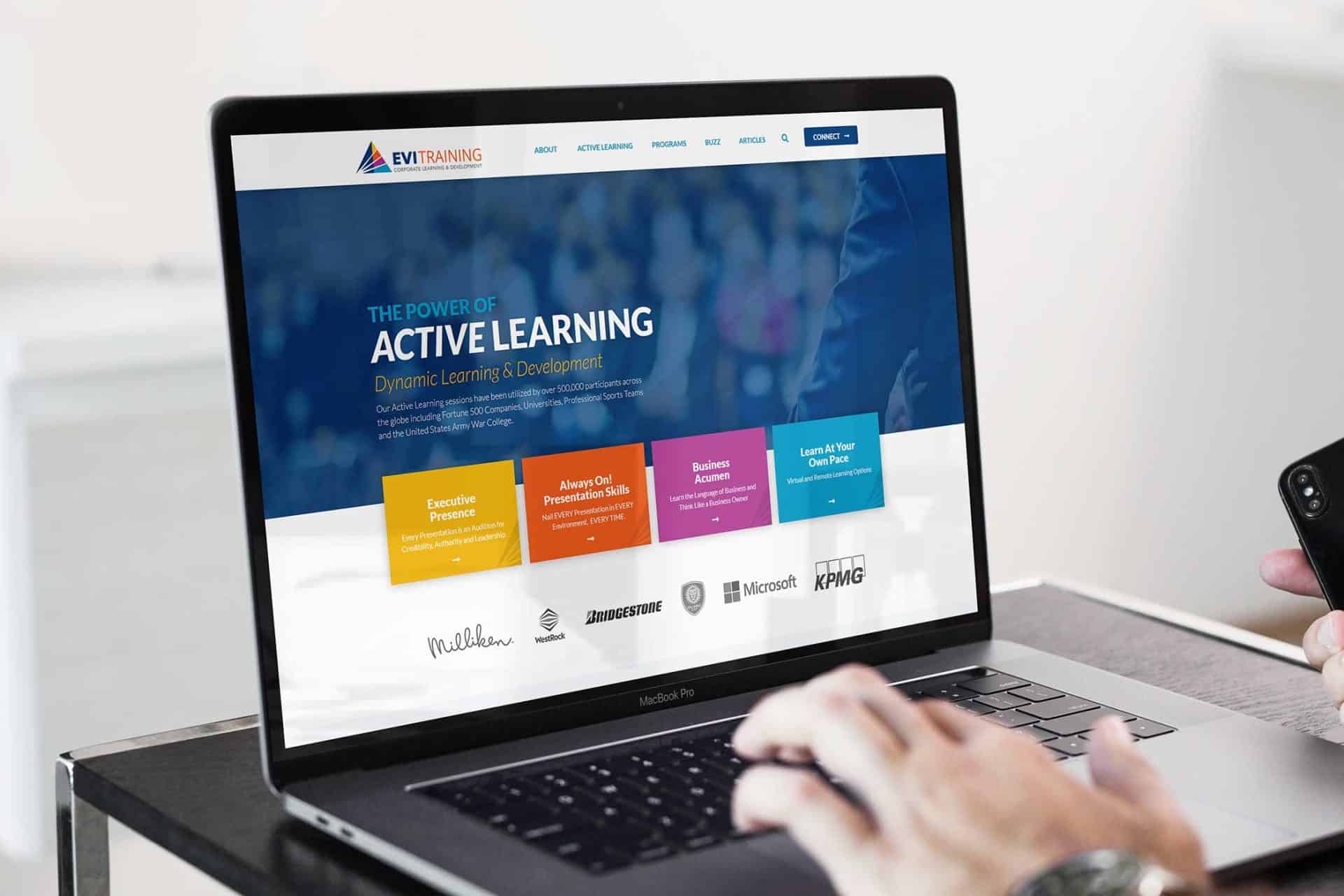 Person typing on a laptop displaying an EVI Training educational website.