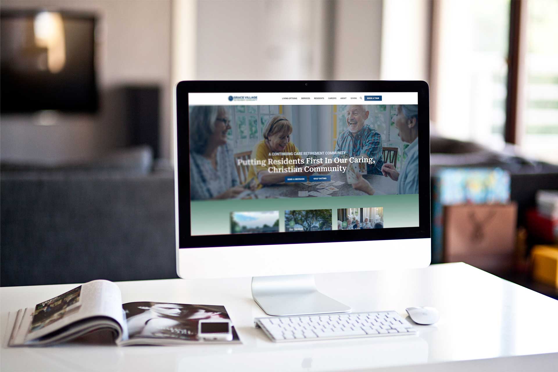 Grace Village: Computer displays website with people meeting image.