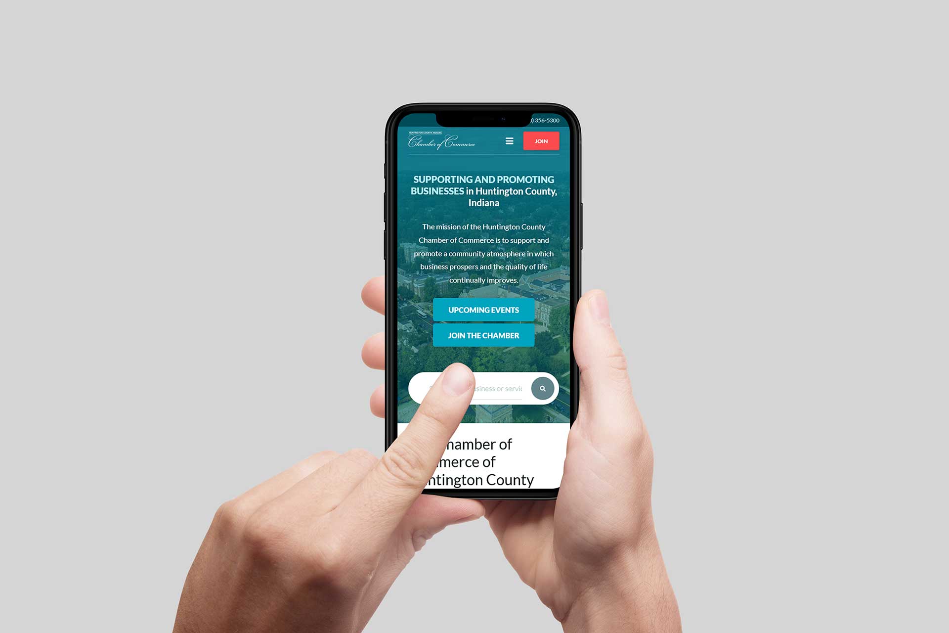 Hands holding a smartphone showcasing Huntington County Chamber of Commerce.