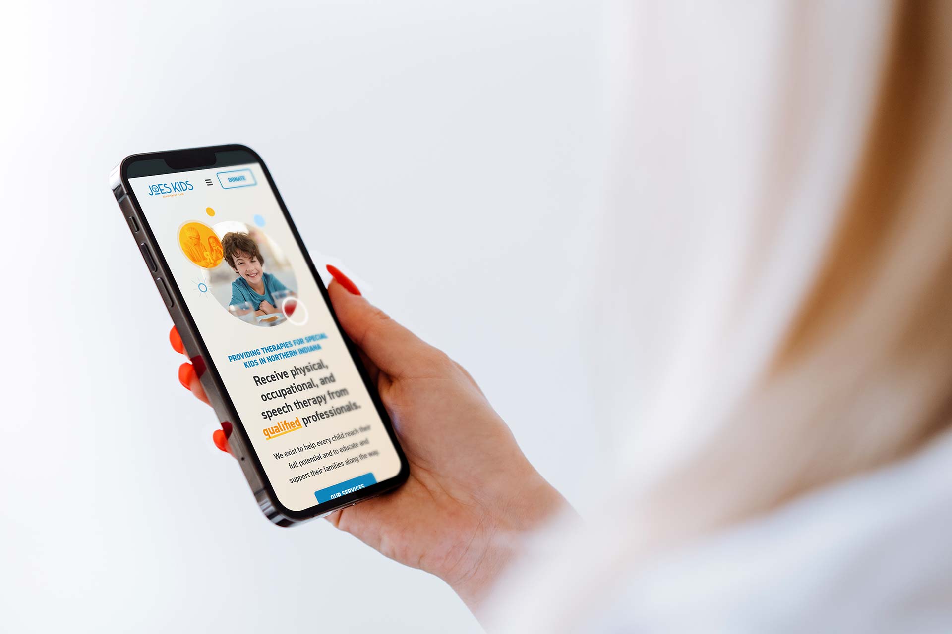 Person holding a smartphone displaying a webpage about child services.