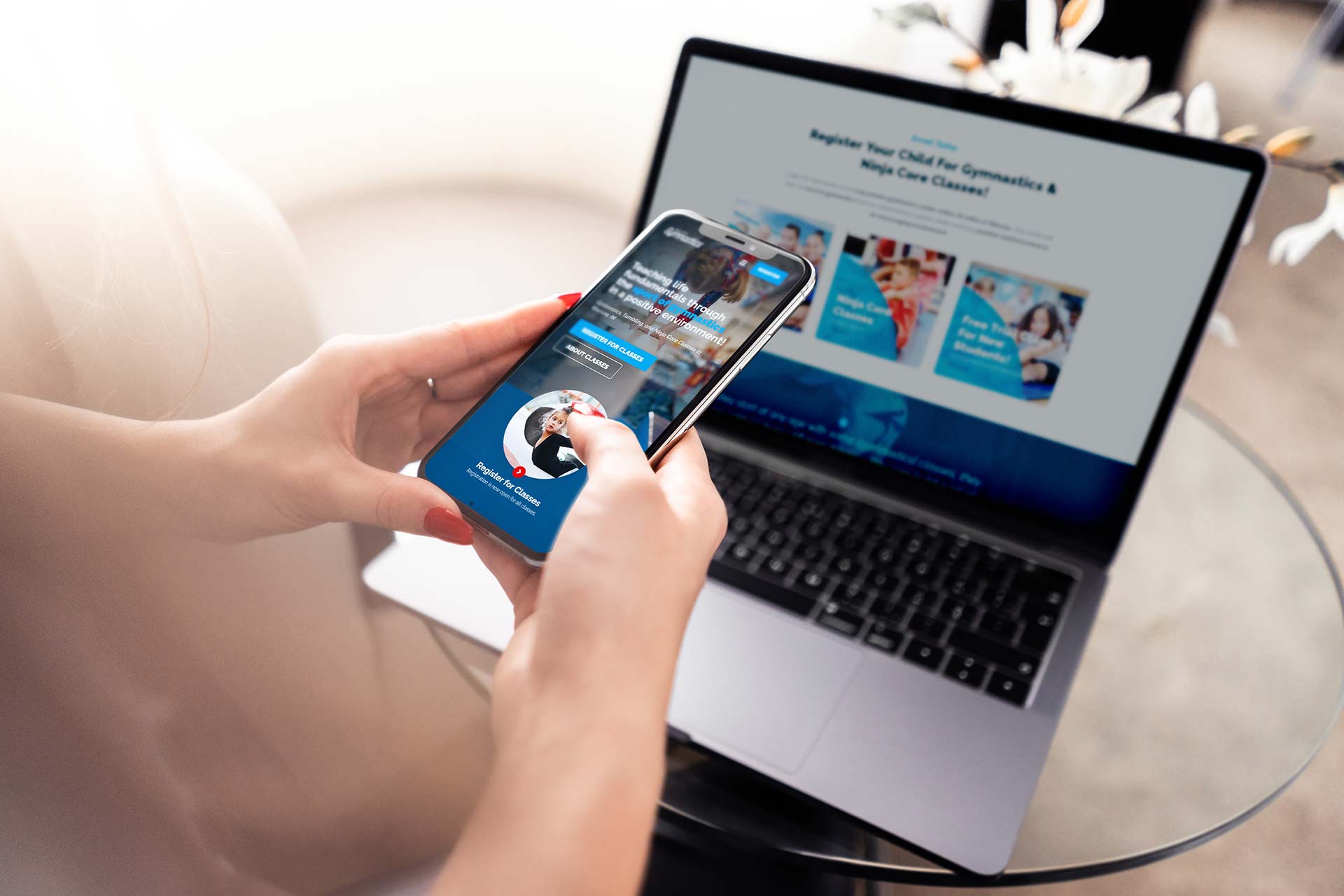 Person using a smartphone with a laptop open near Lake City Gymnastics.