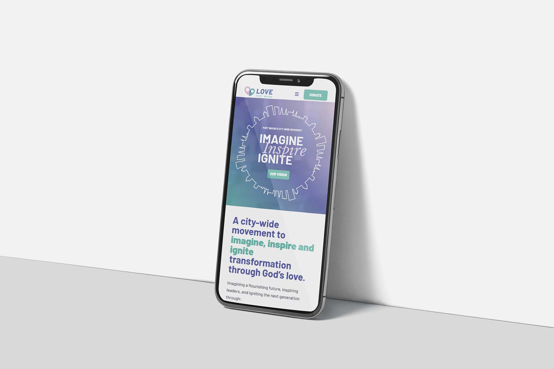 Smartphone showing Love Fort Waynes Imagine, Inspire, Ignite slogan.