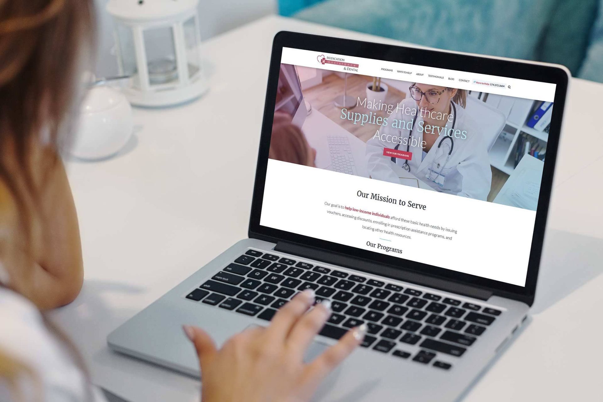 Person using a laptop displaying a healthcare website page.