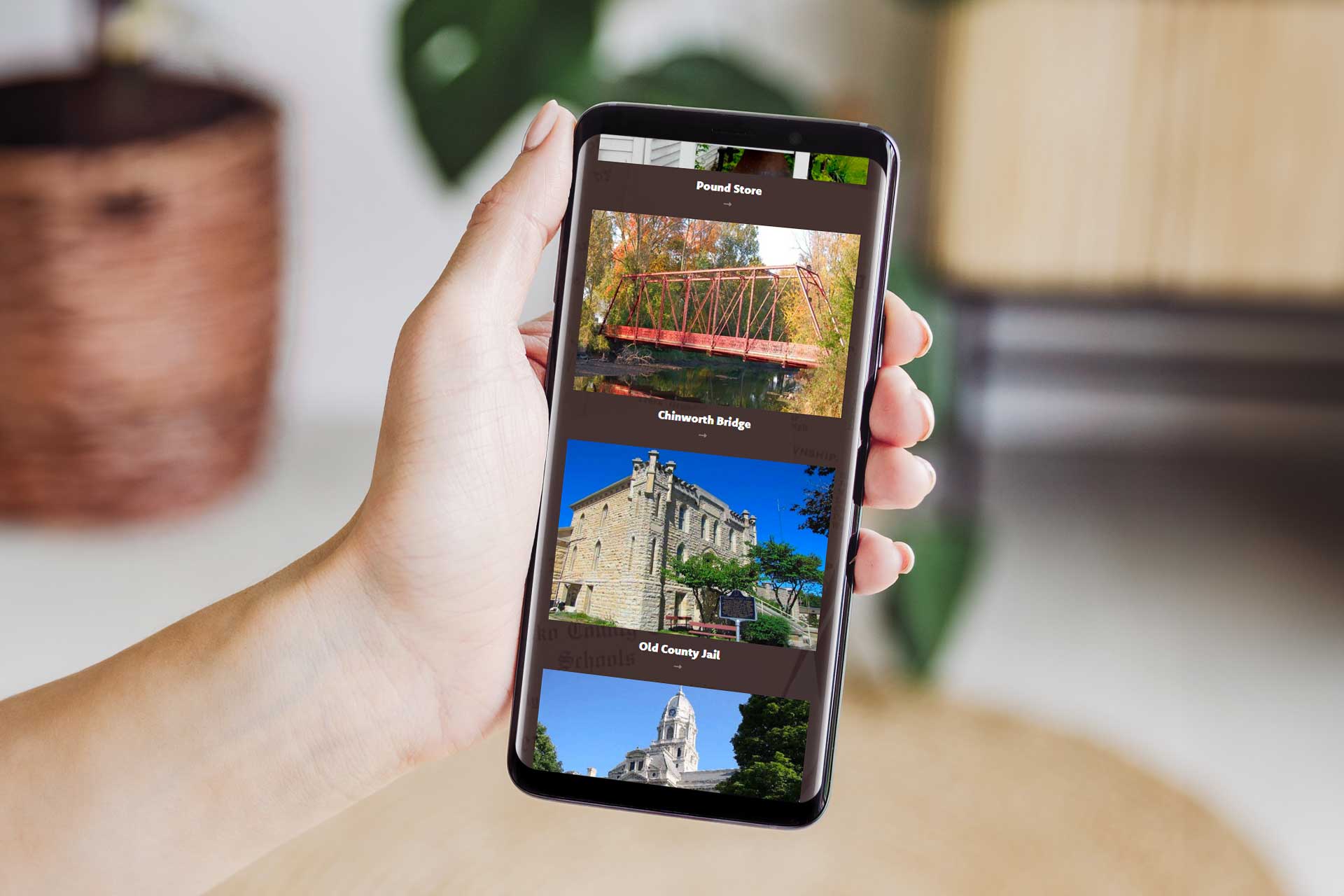 Hand holds a phone showing Kosciusko County Historical Society images.