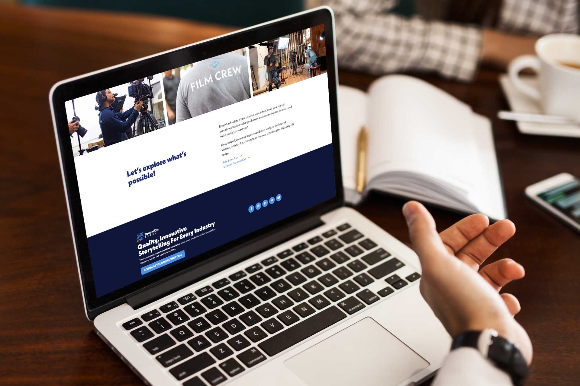 Person viewing DreamOn Studios website on a laptop at a wooden table.