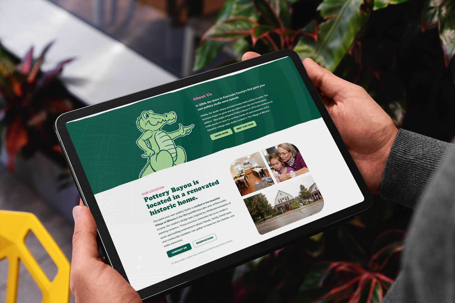 Person holding a tablet showing Poetry at Bayou on the Pottery Bayou website.