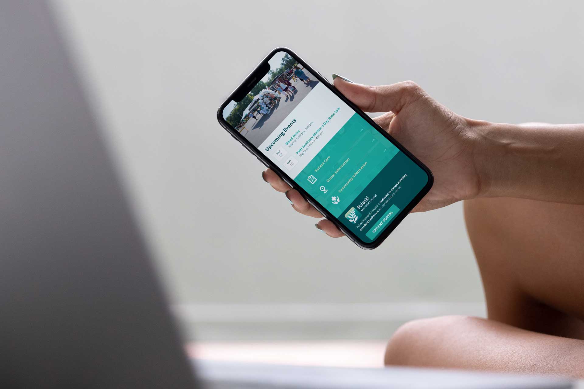 Person using smartphone to view Pulaski Memorial Hospitals app interface.