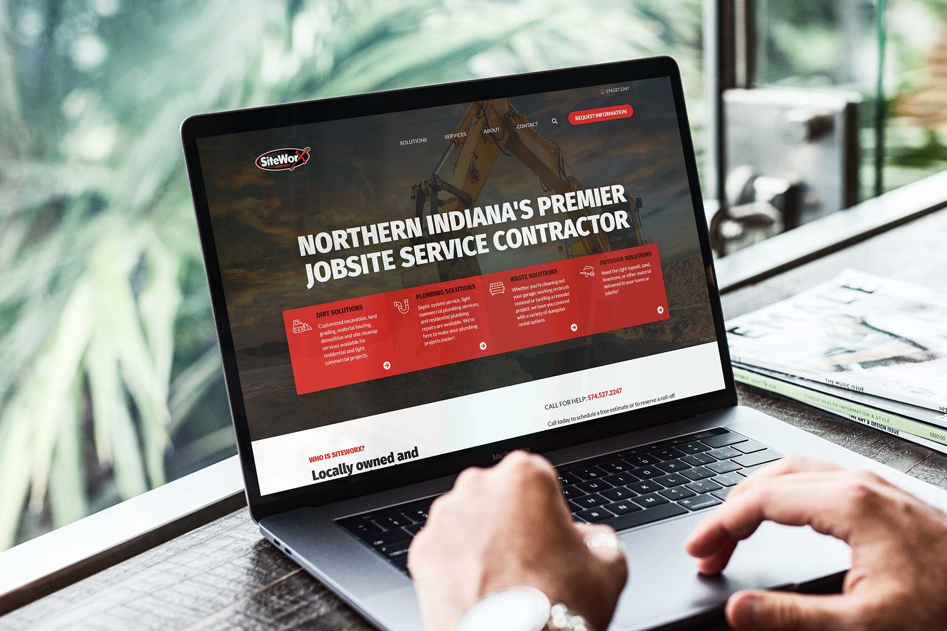 Laptop displaying SiteWorx Services with a construction-themed design.