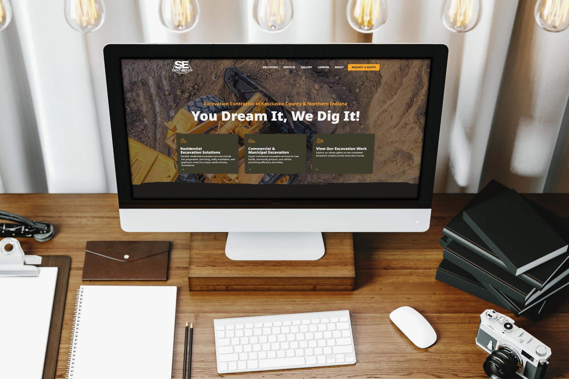 Desktop with a construction company website open on a monitor, seen from above.
