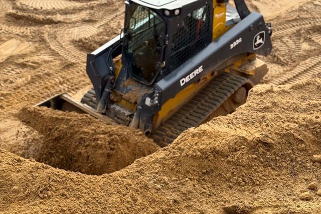 A bulldozer moves sand at a construction site.