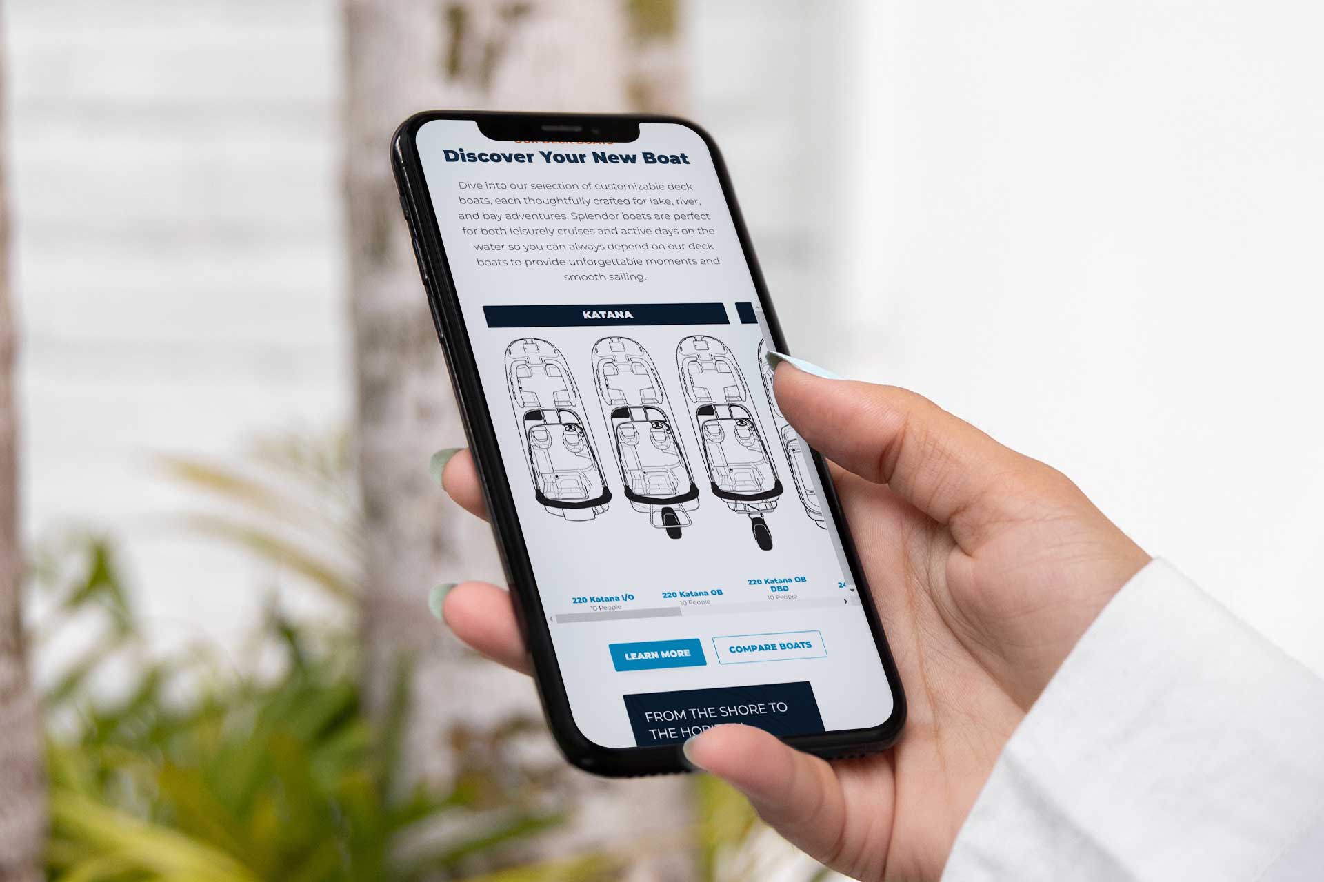 Person holding a smartphone displaying Splendor Boats customization options.