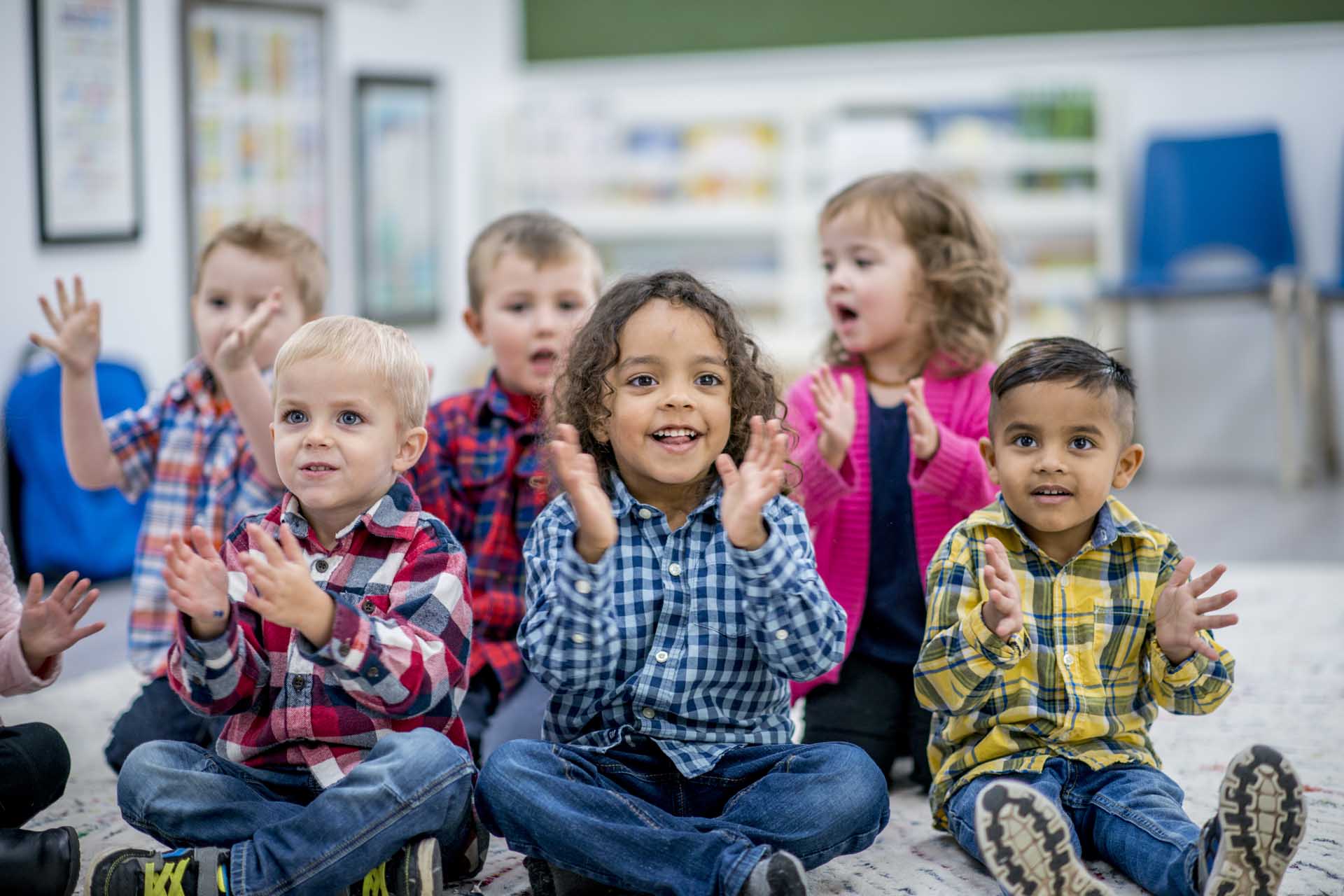 Children clapping in class, supported by United Way of Whitley & Kosciusko.