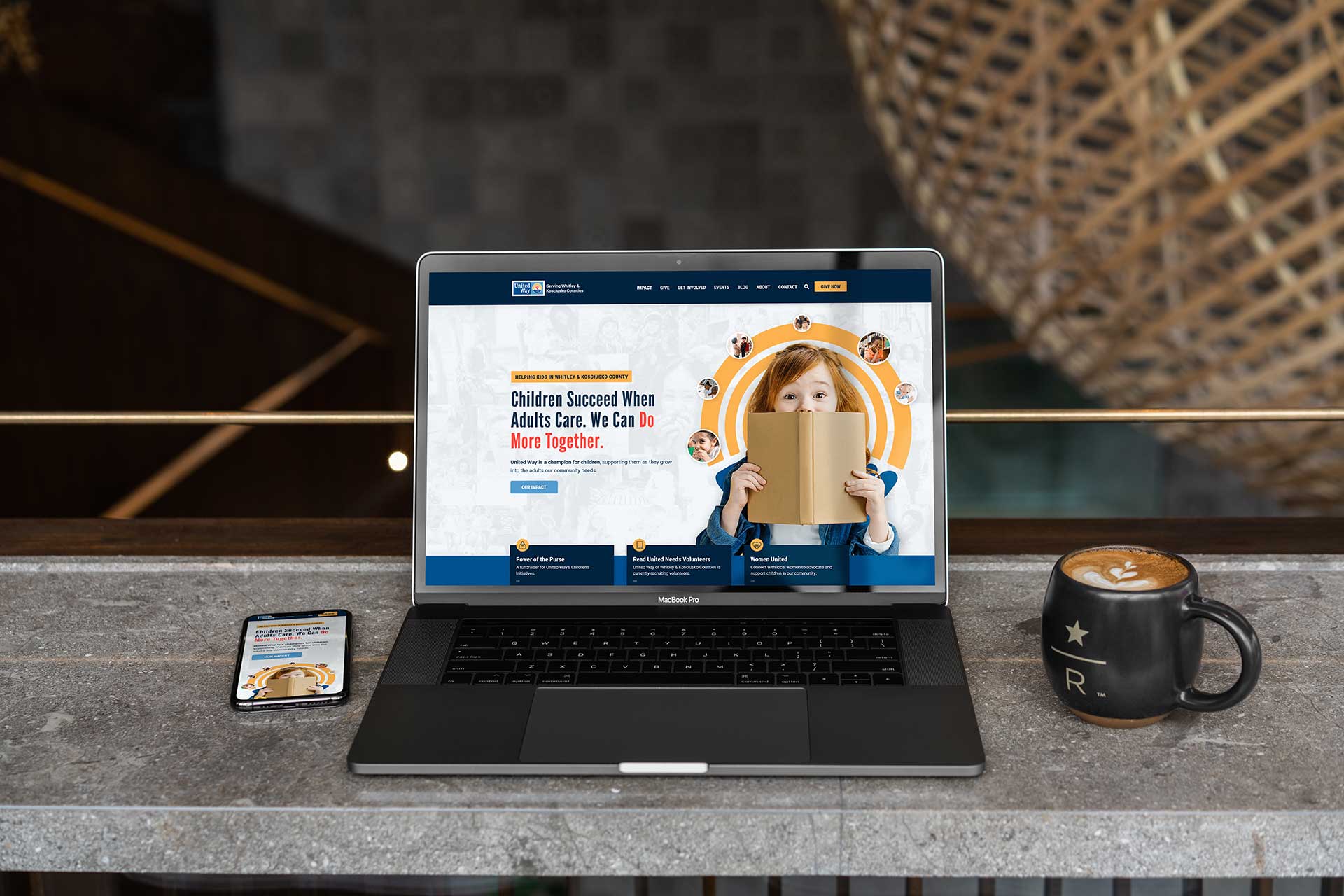 Laptop and phone on a table with United Way of Whitley & Kosciusko Counties site.