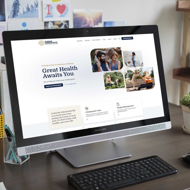 A website for Warsaw Chiropractic on a desktop in a cozy home office.