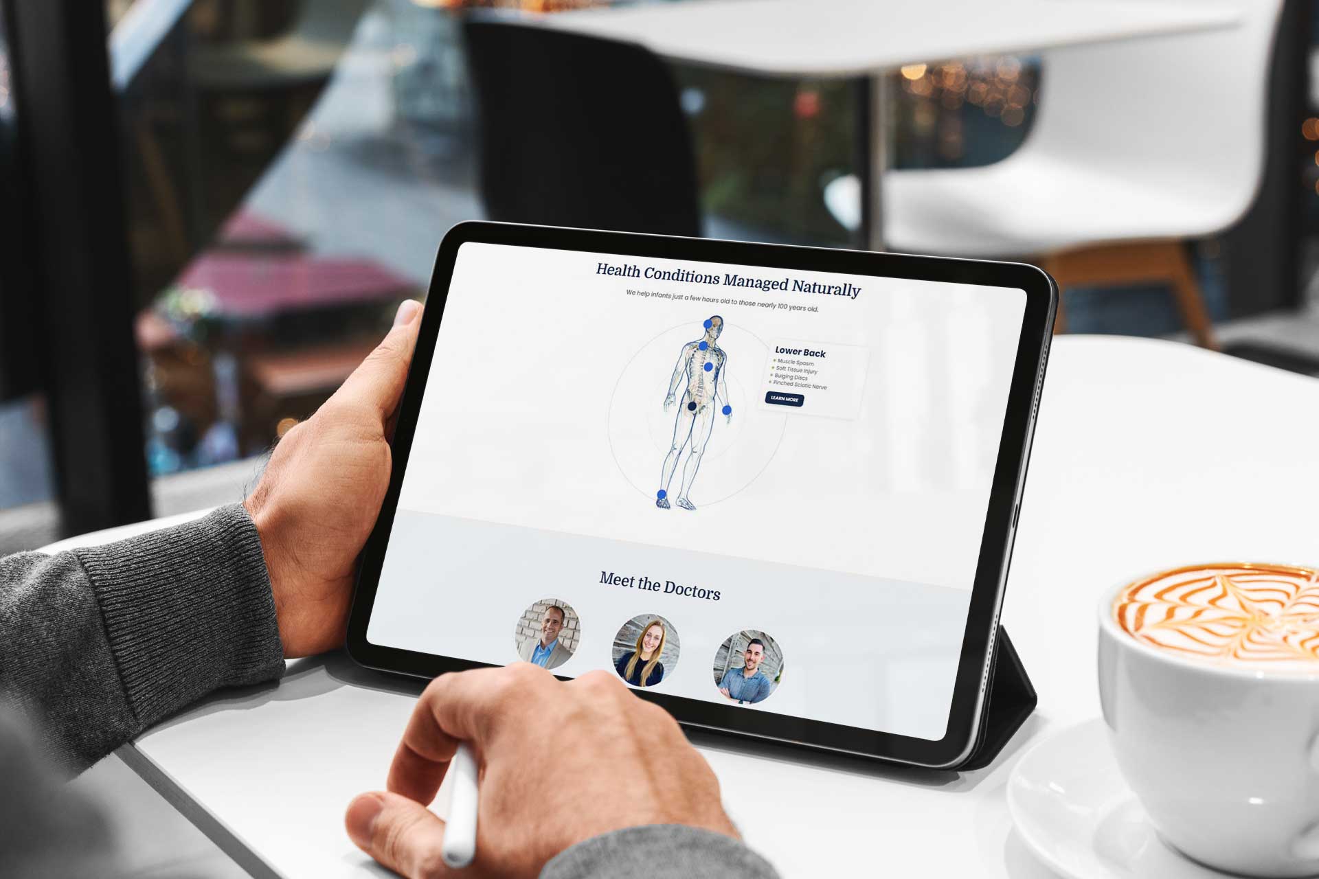 Person viewing Warsaw Chiropractic website on tablet, near a coffee cup.