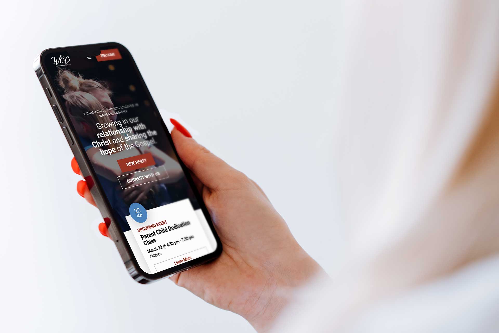 Person holding a smartphone displaying a church website.